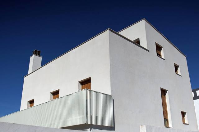 White stucco chimney on a modern flat-roofed building