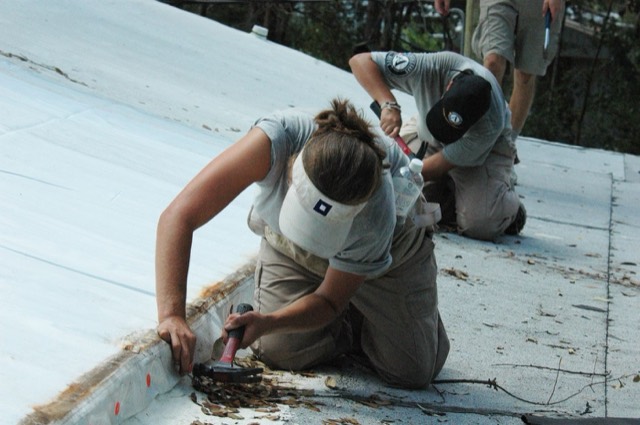 Chimney and roofline being checked after weather — Chimney Leak Repair in Pompano Beach, FL